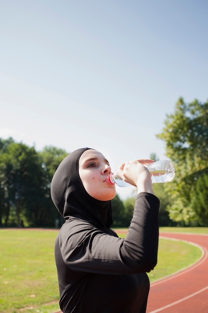 Gratis foto vrouwen drinkwater van plastic fles