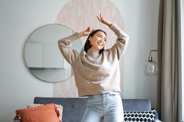 Vrouwen en welzijn mooie jonge aziatische vrouw die danst, zich zorgeloos en gelukkig voelt en haar handen opsteekt