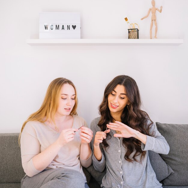 Vrouwen geven manicure aan zichzelf