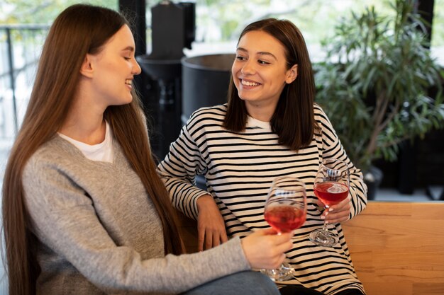 Vrouwen glimlachen en houden glazen wijn vast