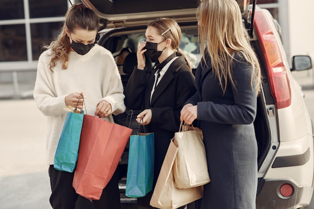 Vrouwen in maskers lopen naar buiten met boodschappentassen