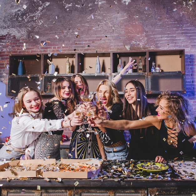 Vrouwen koppelen glazen champagne samen