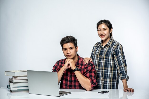 Vrouwen leren mannen op het werk met laptops te werken.