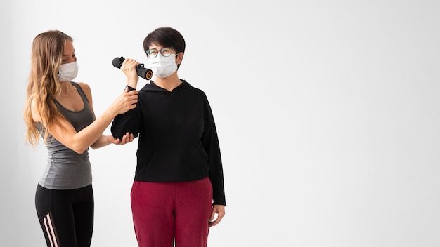 Vrouwen met gezichtsmaskers die met exemplaarruimte trainen
