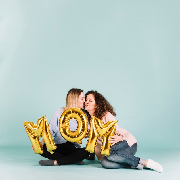 Vrouwen met moeder schrijven zittend op de vloer