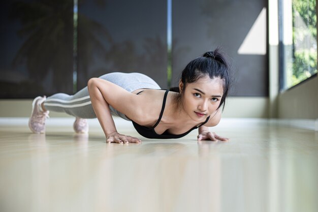 Vrouwen oefenen door de vloer in de sportschool te duwen