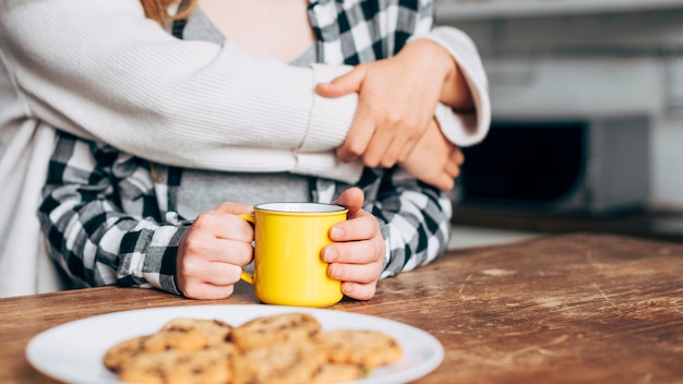 Vrouwen omarmen zittend aan tafel