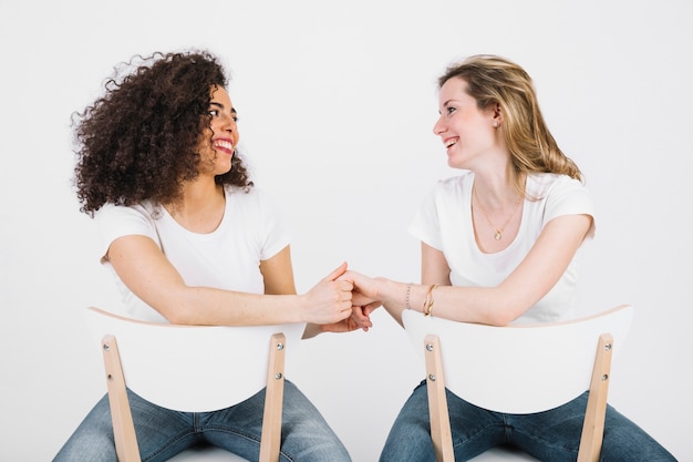 Vrouwen op stoelen die handen houden