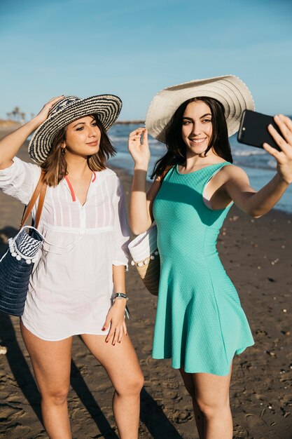 Vrouwen poseren voor selfie op het strand