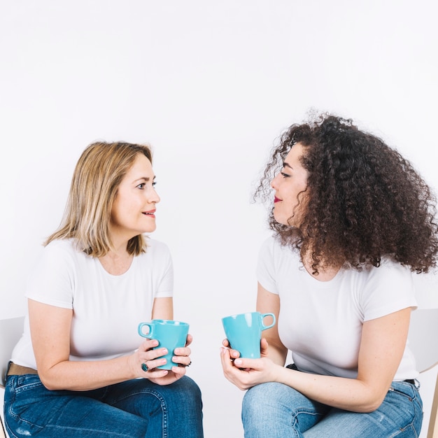 Vrouwen praten met mokken