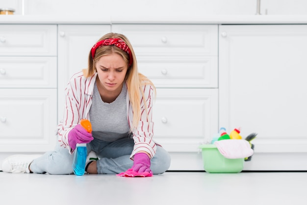 Vrouwen schoonmakende vloer zorvuldig