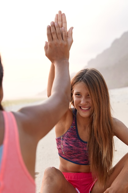 Vrouwen van gemengd ras geven elkaar een high five, omdat ze in een goede bui zijn