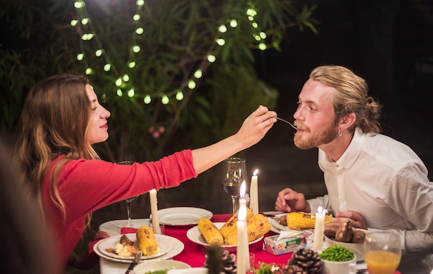 Vrouwen voedende man met lepel bij vakantiediner