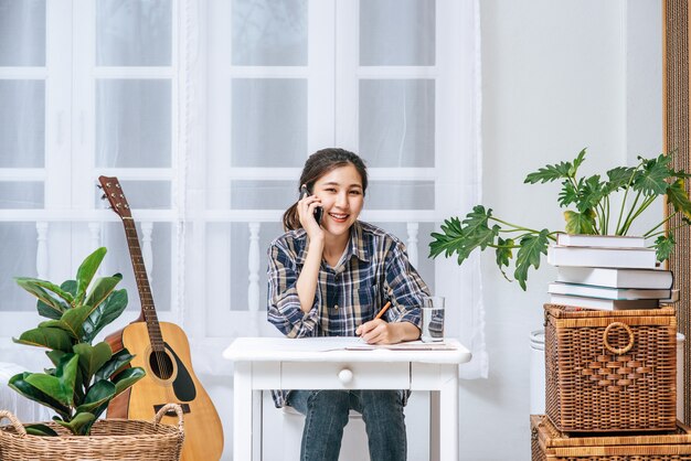 Vrouwen zitten aan het bureau en gebruiken de telefoon om te coördineren.