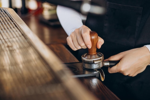 Vrouwenbarista bij een koffiewinkel die koffie bereidt