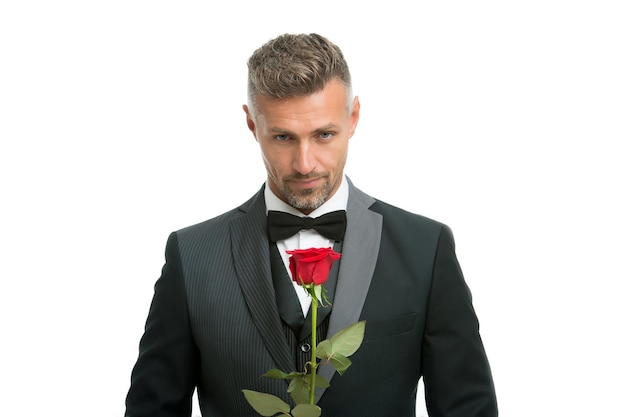 Vrouwendag vieren. knappe man houdt rode roos vast. bloemen voor vrouwendag. bachelor in formele kleding. internationale vrouwendag. 8 maart. bloemencadeau op vrouwendag.
