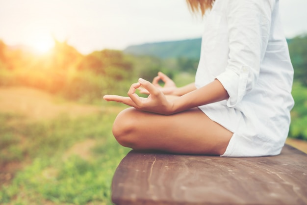 Gratis foto vrouwenhanden yoga meditaties en het maken van een zensymbool met haar ha