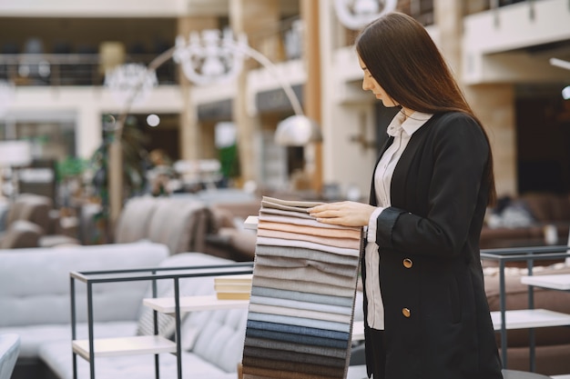 Gratis foto vrouwenklant die mooie stof in gordijnwinkel zoeken