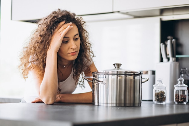 Vrouwenkooktoestel die deegwaren maken bij de keuken