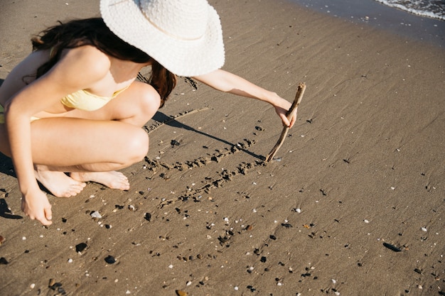 Vrouwentekening in het zand bij het strand