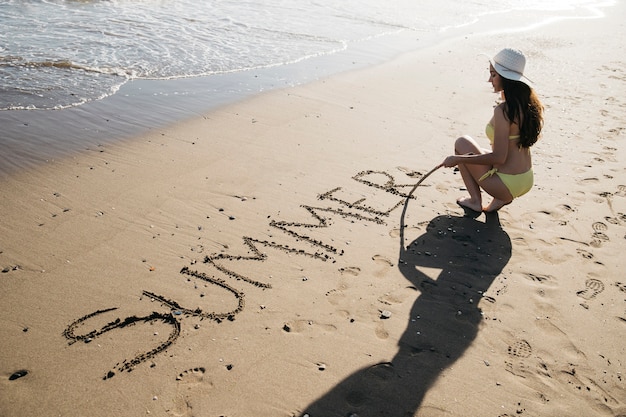 Gratis foto vrouwentekening in het zand bij het strand