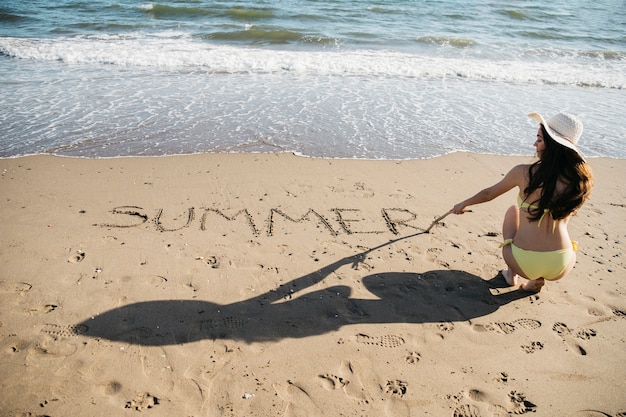 Gratis foto vrouwentekening in het zand bij het strand