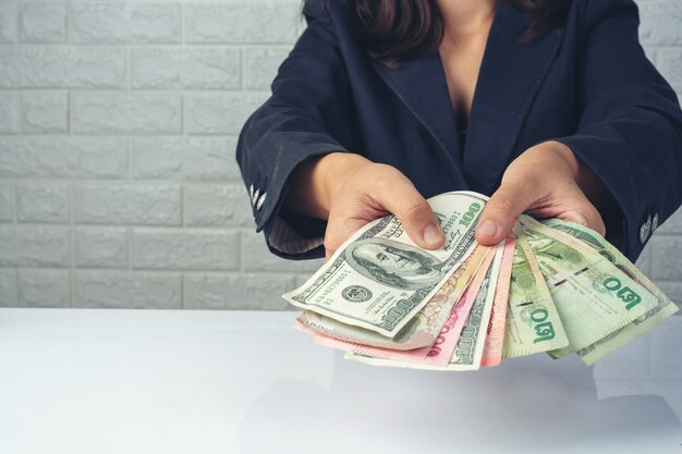 vrouwenwerknemers die geld op een wit bureau tellen