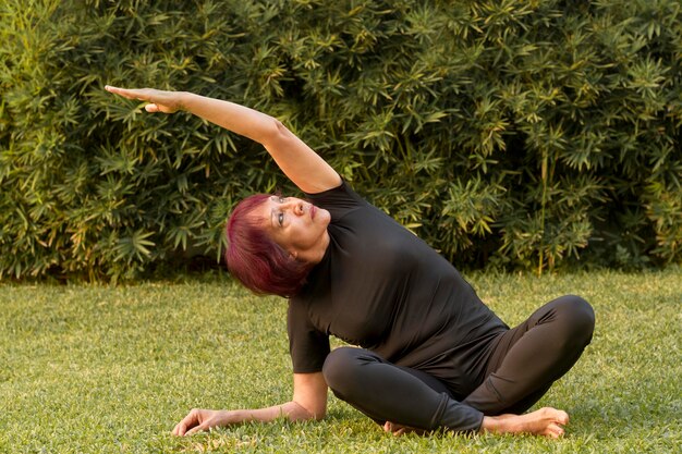 Vrouwenzitting in yogapositie en het uitrekken zich