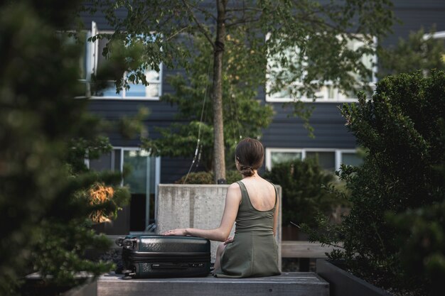 Vrouwenzitting met een koffer in het park