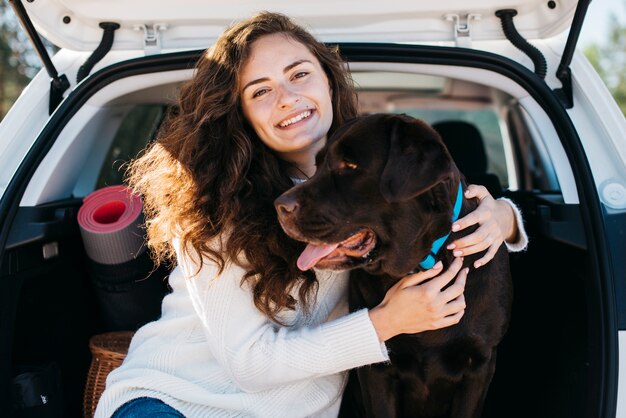 Vrouwenzitting met haar hond in open boomstam