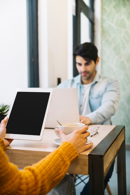 Gratis foto vrouwenzitting met tablet en koffie