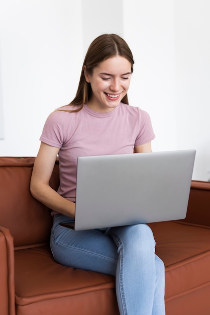 Vrouwenzitting op laag terwijl het controleren van haar laptop