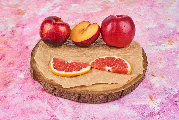 Vruchten op een houten bord op roze.