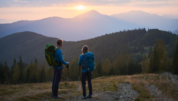 Wandelen in de bergen bij zonsondergang in de zomer