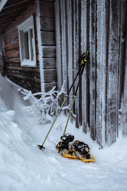 Gratis foto wandelstok en sneeuwschoenen door ajds houten muur