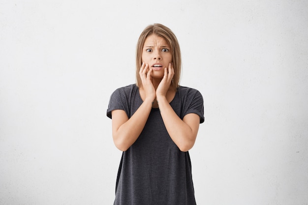 Wat ik heb gedaan?! bange jonge vrouw van gemengd ras met grote ogen die er doodsbang en bang uitzag