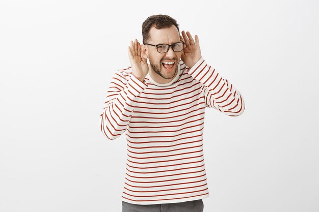 Wat kan je niet horen. Portret van ongemakkelijke intense knappe volwassene met varkenshaar in glazen