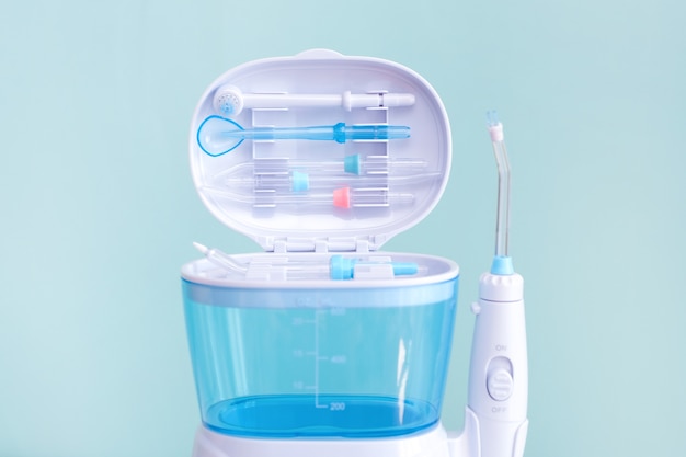 Waterflosser, tandheelkundige monddouche op een blauwe achtergrond. verzorging van tandheelkundige apparatuur. irrigator voor mond