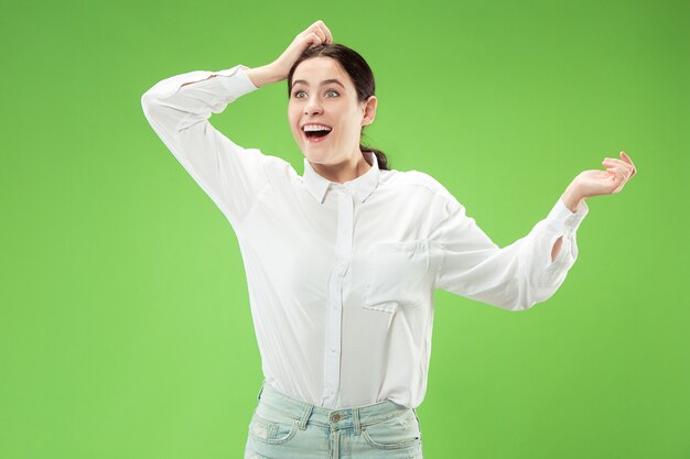 Wauw. Mooi vrouwelijk half-lengte voorportret dat op groene studio wordt geïsoleerd