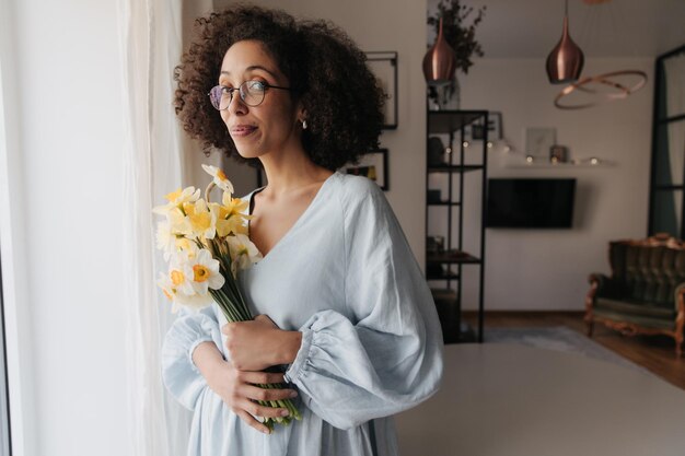 Weergave van zwarte vrouw die lacht naar de camera met bloemen