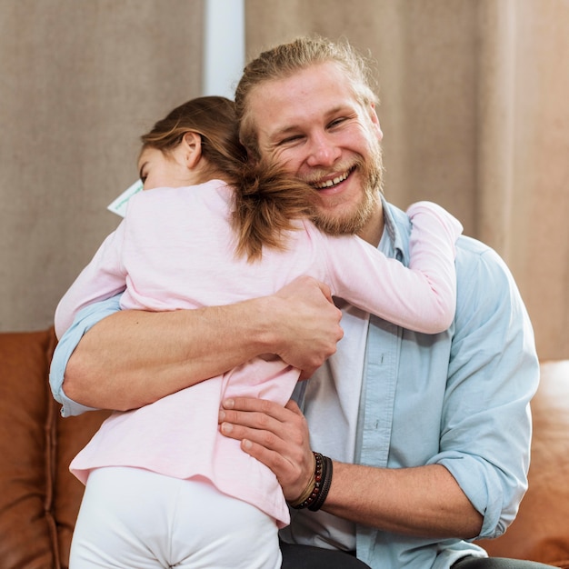 Gratis foto weinig dochter die smileyvader omhelst