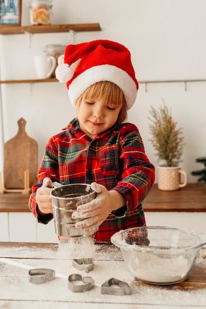 Gratis foto weinig jongen die een kerstmiskoekje maakt