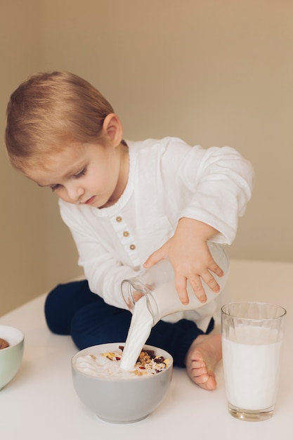 Weinig jongen die melk toevoegt aan graangewassen