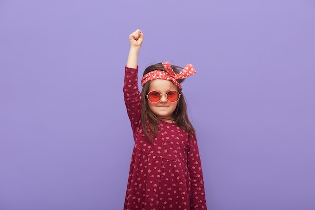 Weinig modieus rebellenmeisje gekleed in kleding