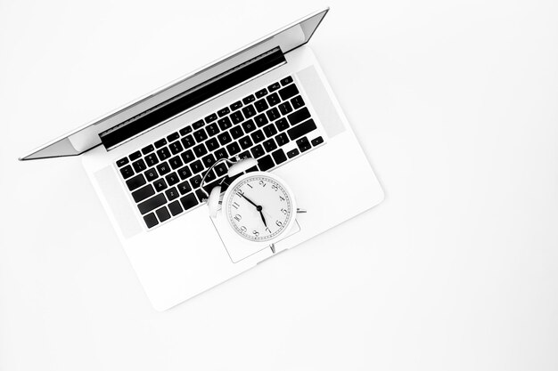 Wekker en een laptop op een witte achtergrond bovenaanzicht