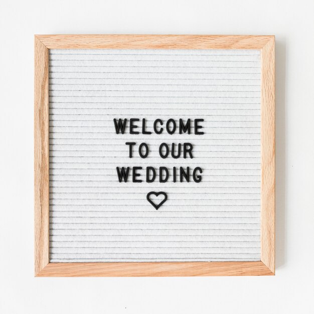 Welkomsttekst voor huwelijk op houten frame tegen witte achtergrond