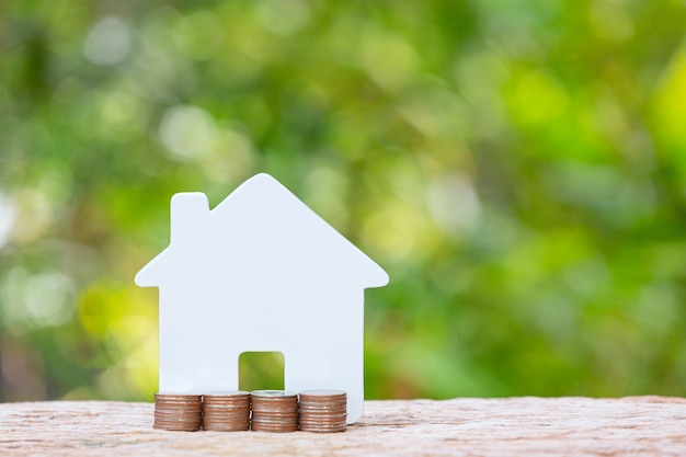 Wereld Habitat Dag, close-up foto van een stapel munten en een modelwoning