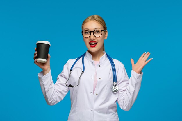 Wereldartsendag lachende arts zwaaiende handen met koffiekopje en stethoscoop in de medische jas