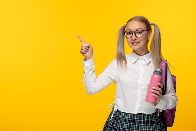 Wereldboekendag gelukkig blond schoolmeisje in schattig uniform met roze fles