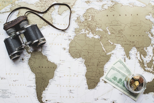 Wereldkaart achtergrond met geld en verrekijkers